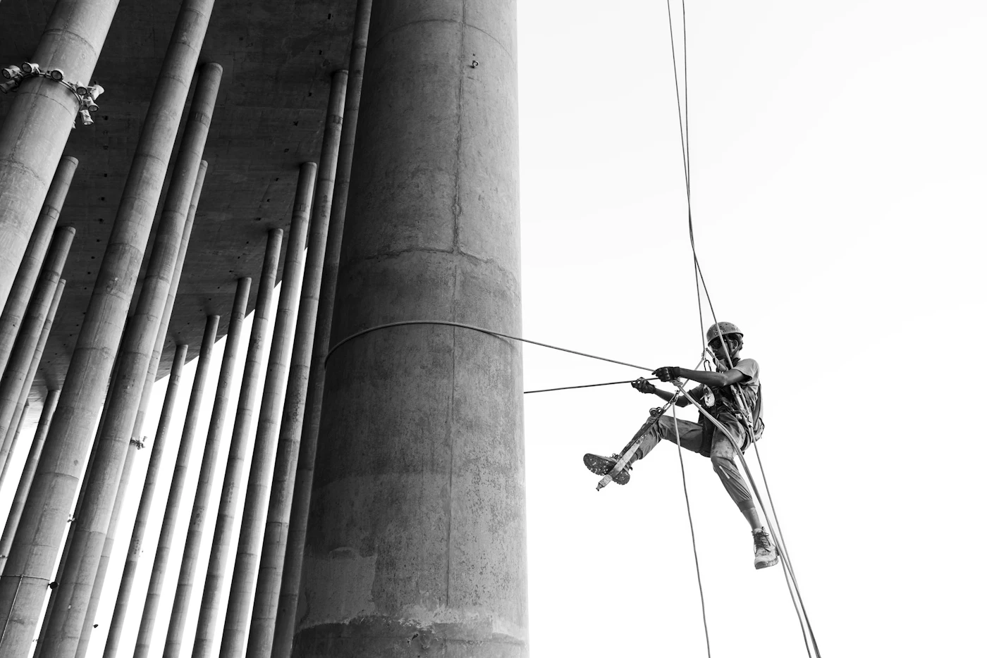 Technician rappelling down a tall concrete structure